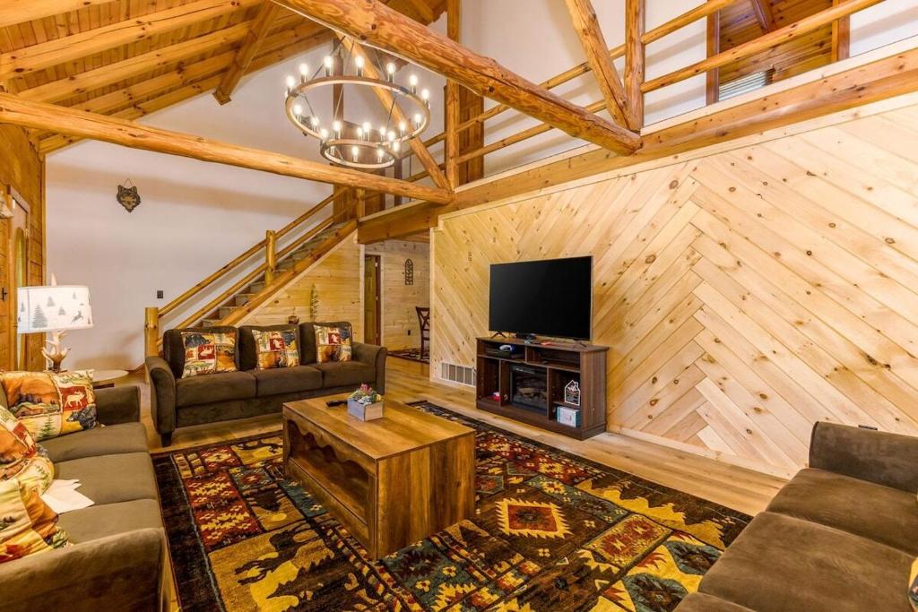 un soggiorno con un divano e una TV di Luxury Spacious Cabin Hot Tub, Theater, 5 Acres in Hocking Hills a Logan