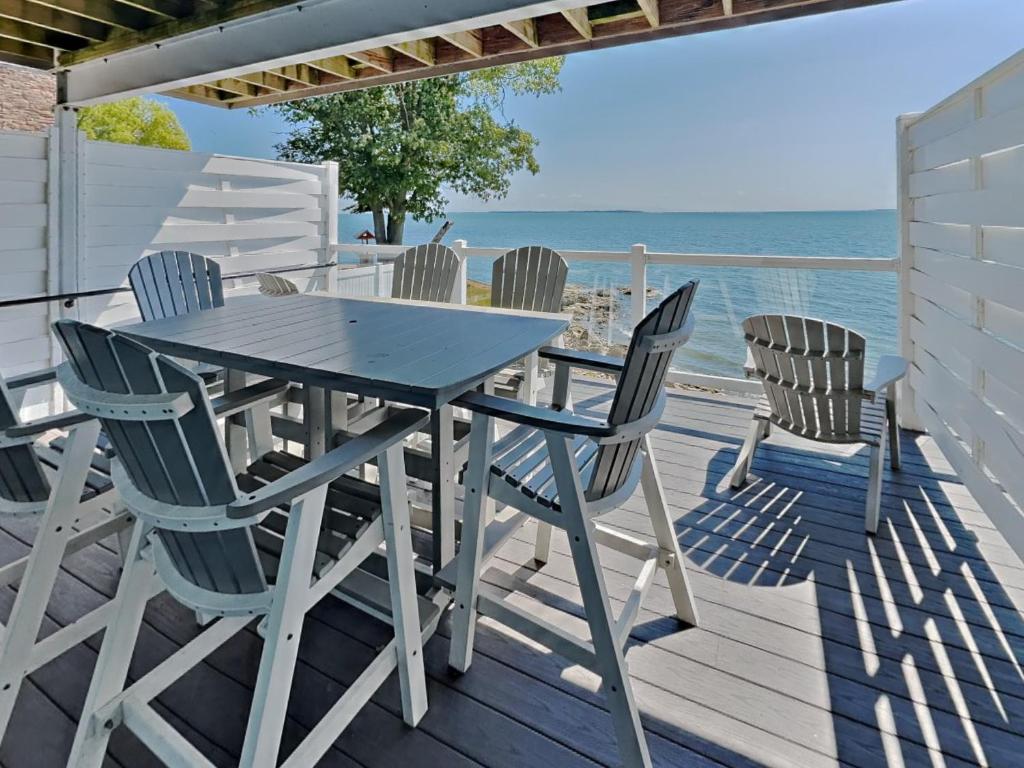 a table and chairs on a deck with the ocean at Put-in-Bay Waterfront Condo #113 in Put-in-Bay