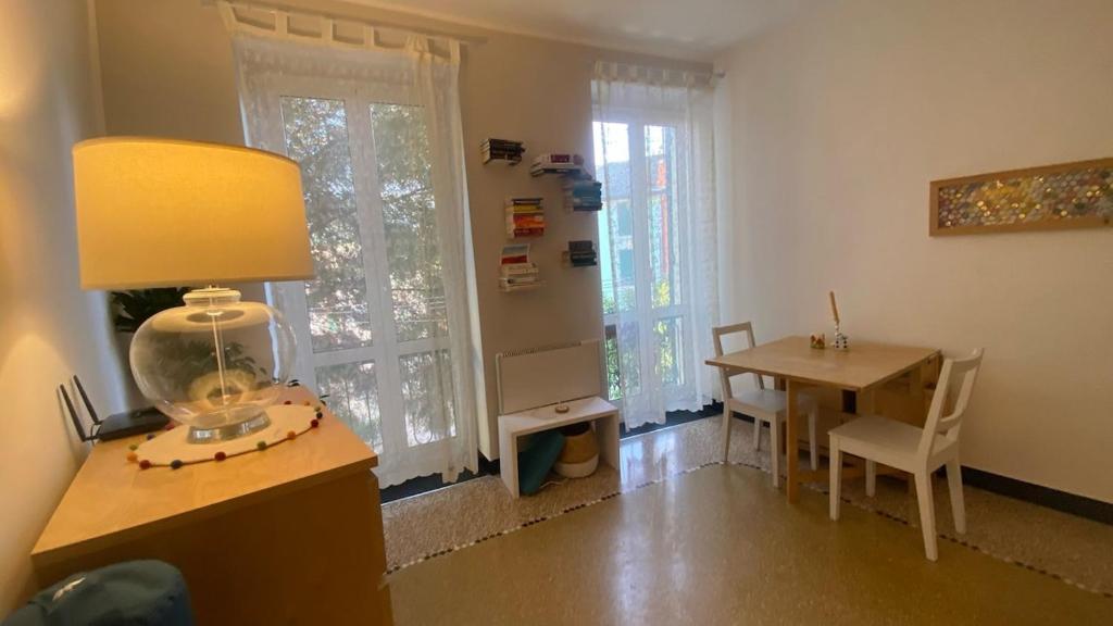 a living room with a desk and a table with a lamp at Lovely apartment in the old town, near the beach in Arenzano