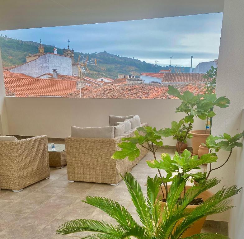 a balcony with chairs and a view of a city at El Rincón de Serradilla in Serradilla