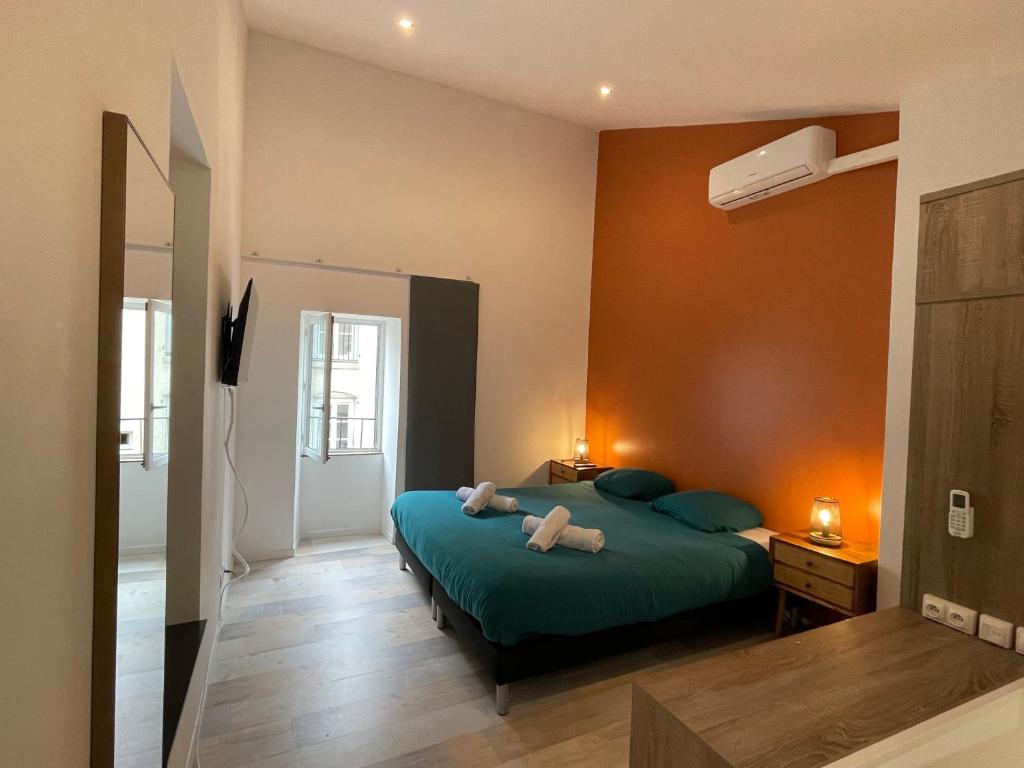 a bedroom with a green bed with two pillows at Duplex cosy in Chabeuil