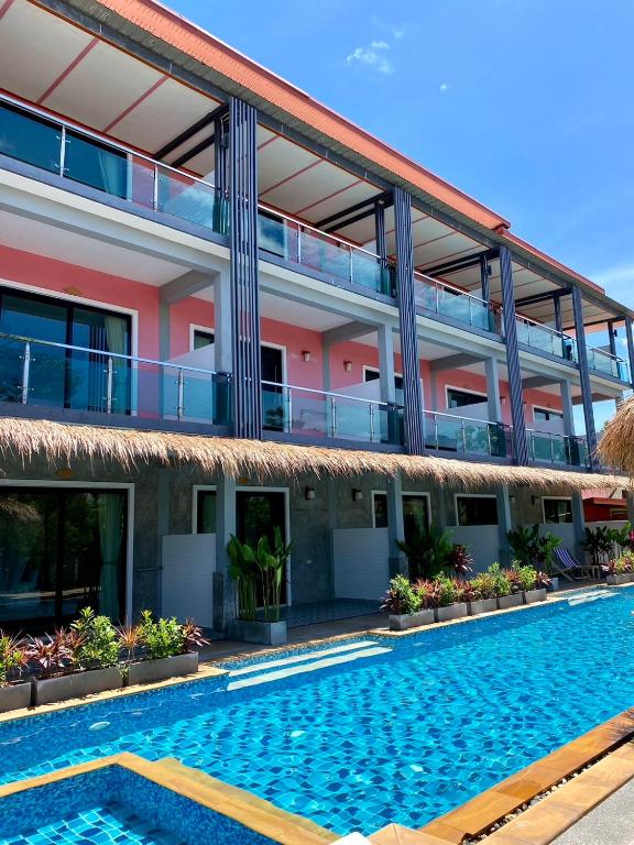 a hotel with a swimming pool in front of a building at Lanta Just Come Resort in Ko Lanta Yai