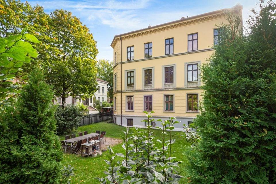 een groot geel gebouw met een picknicktafel in een tuin bij Just steps behind the Royal Palace in Oslo