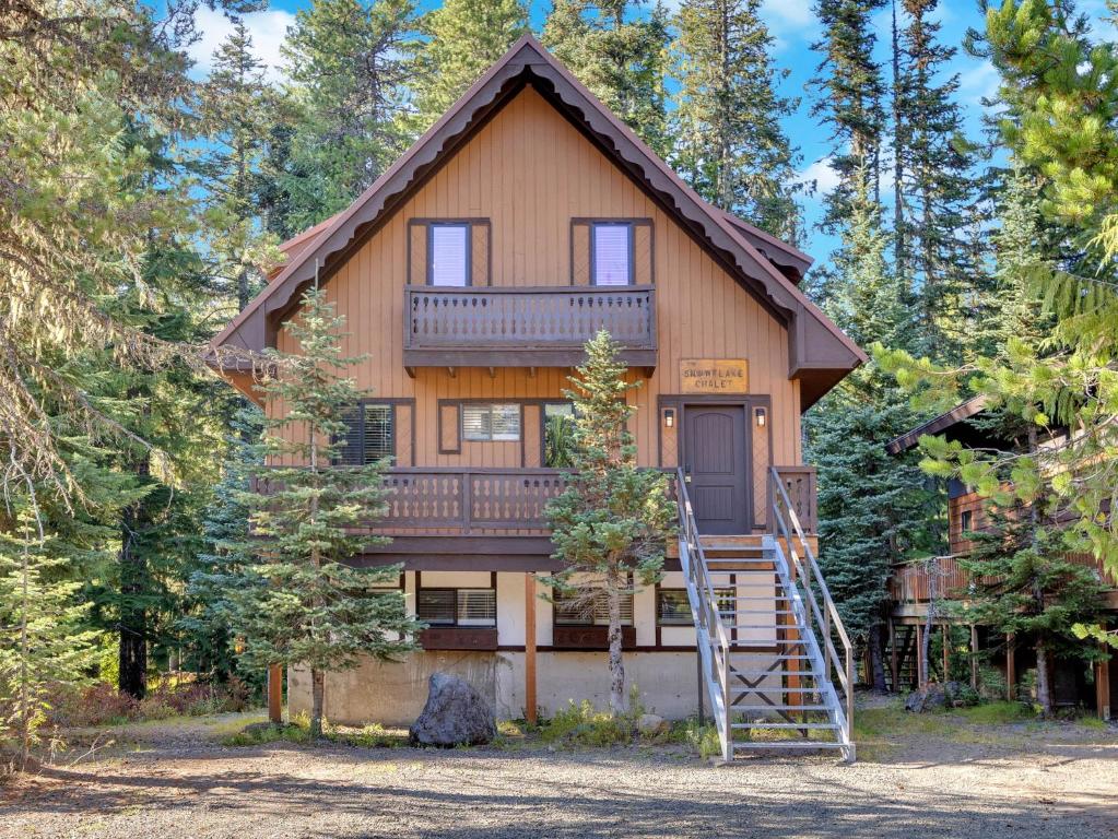 a large wooden house with a staircase in front of it at Snowflake Chalet in Government Camp