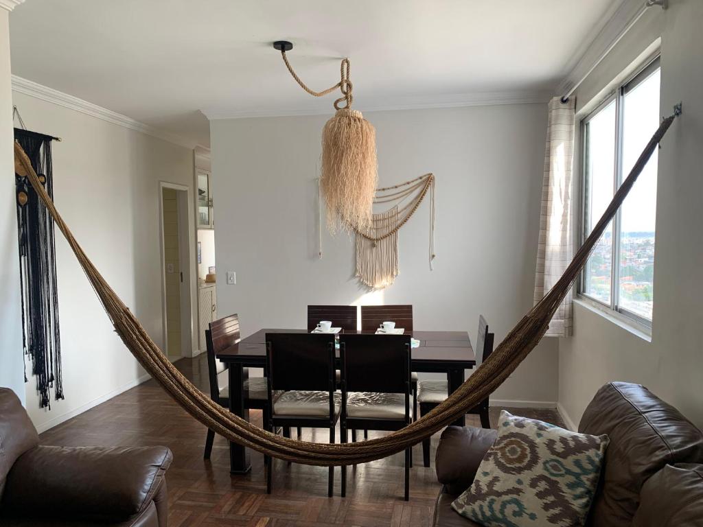 a dining room with a table and a hammock at Spacious & Artistic Apartment in Belém in Belém