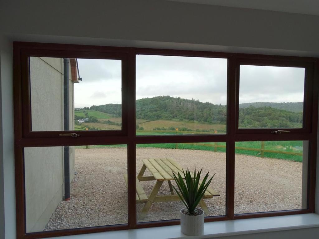 a window with a view of a table and a bench at Forrest view in Dunfanaghy