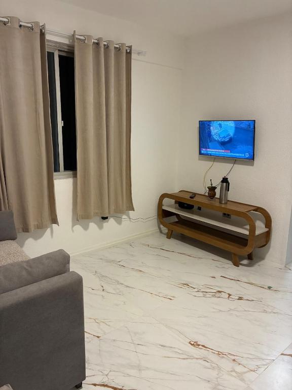 a living room with a couch and a flat screen tv at Apartamento albion in Porto Alegre