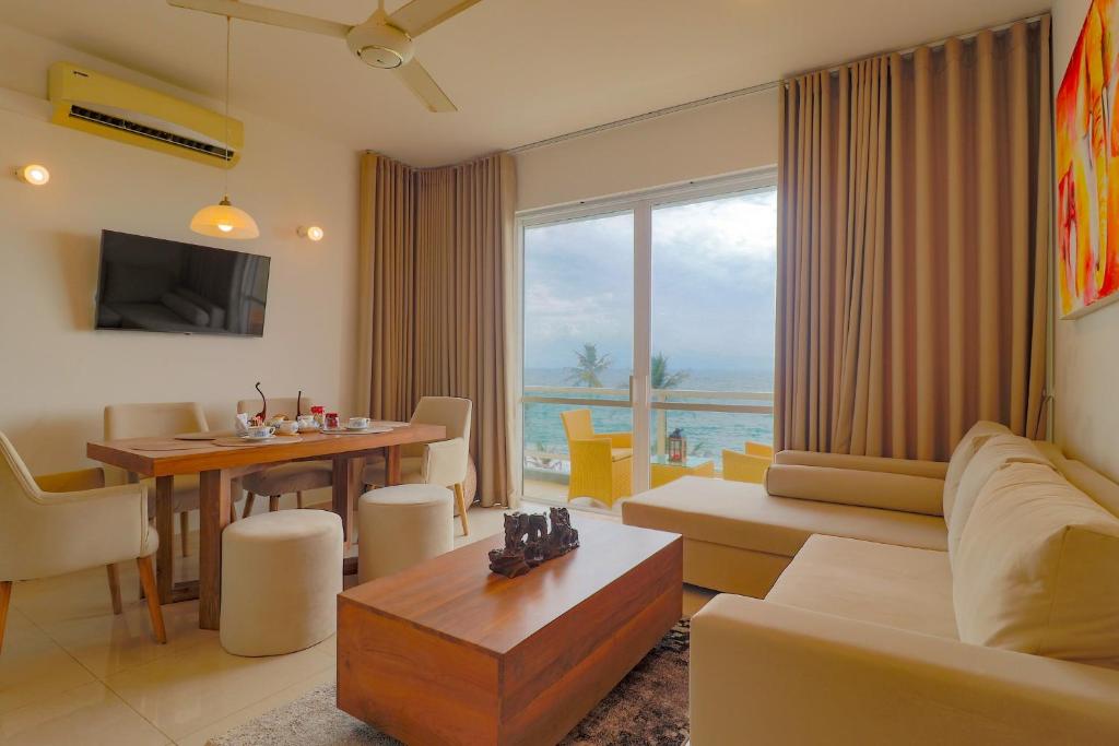 una sala de estar con un sofá y una mesa en Savno Residency, en Uswetakeiyawa