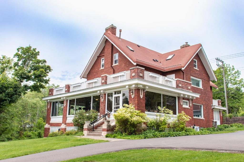 a large red brick house with a porch at Historic GG Barnum Mansion by Heirloom Boutique Collection in Duluth