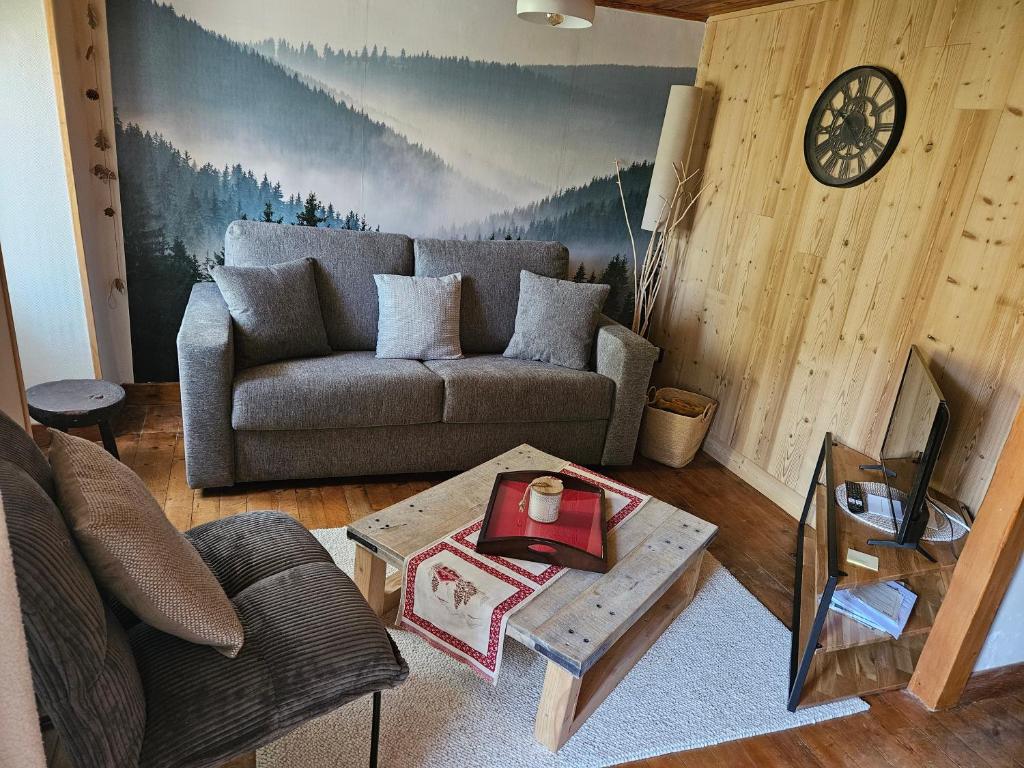 a living room with a couch and a table at Maison de montagne in La Llagonne