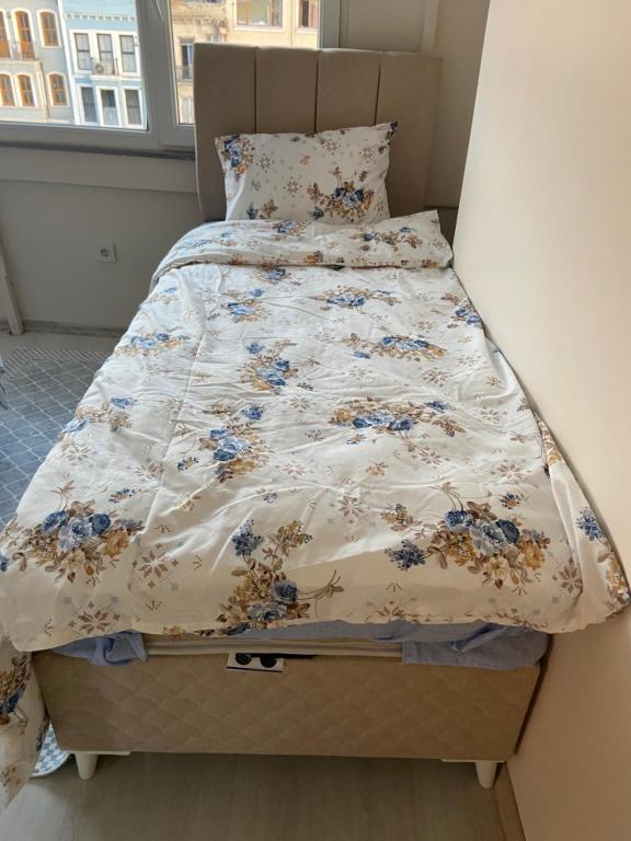 a bed with a floral comforter in a bedroom at HOmE SUITE in Istanbul