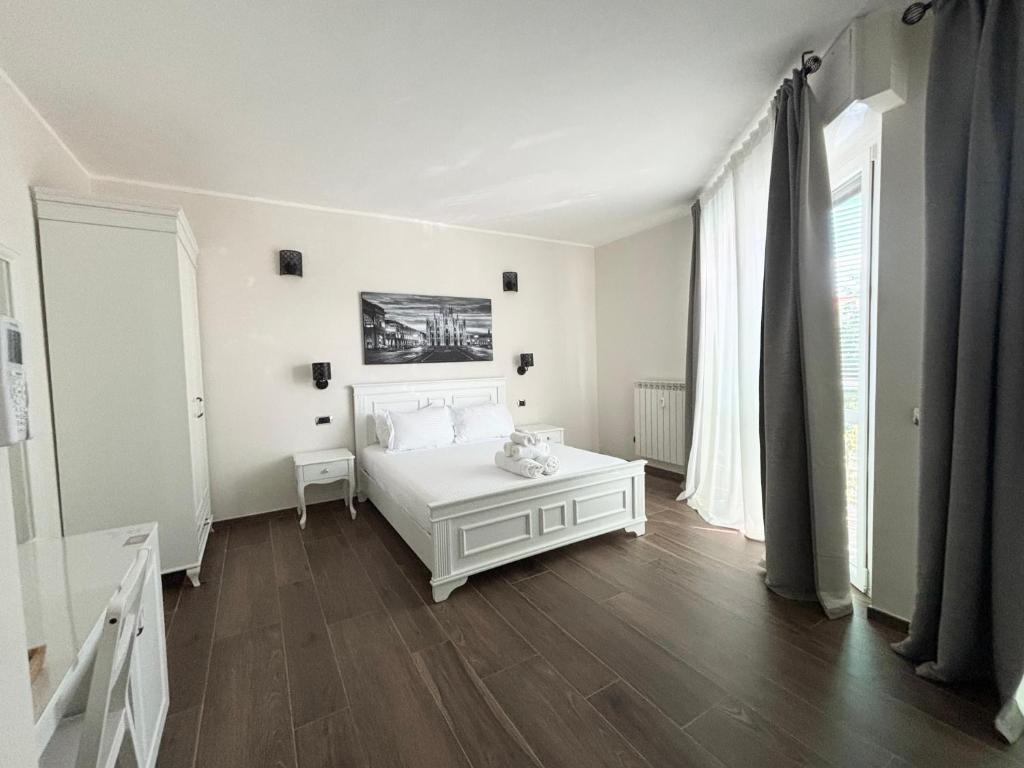 a bedroom with a white bed and a wooden floor at San Siro House in Milan