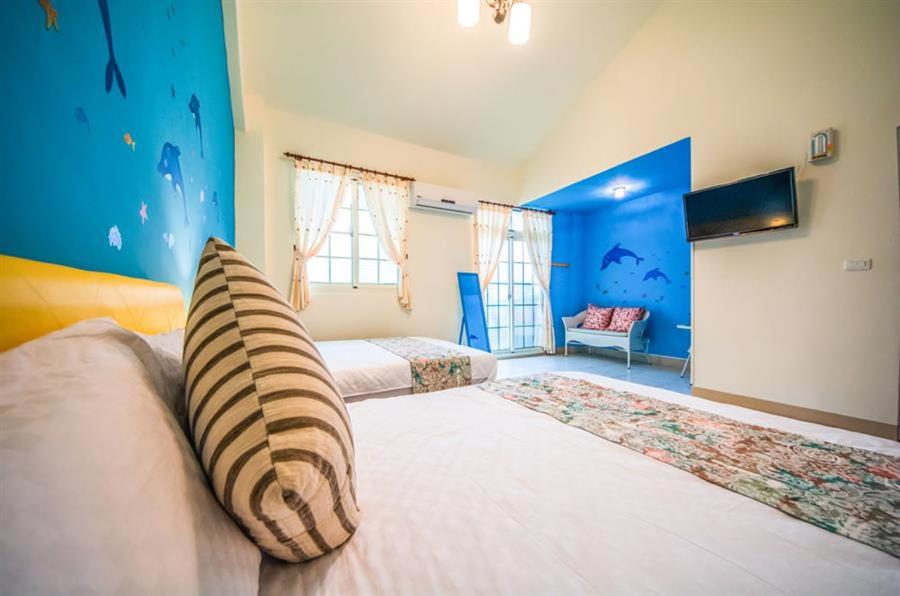 een slaapkamer met een groot bed met een kussen erop bij Together B&B in Hualien