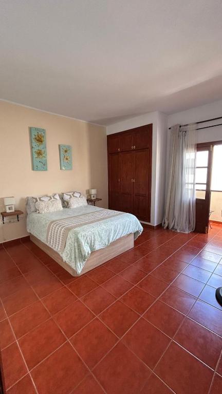 a bedroom with a bed and a tiled floor at Casa Ramos in Arrecife