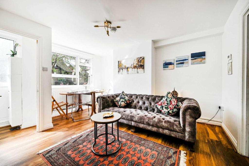 una sala de estar con un sofá y una mesa en Riverside 1 Bed Flat with Parking at Kingston, en Kingston upon Thames