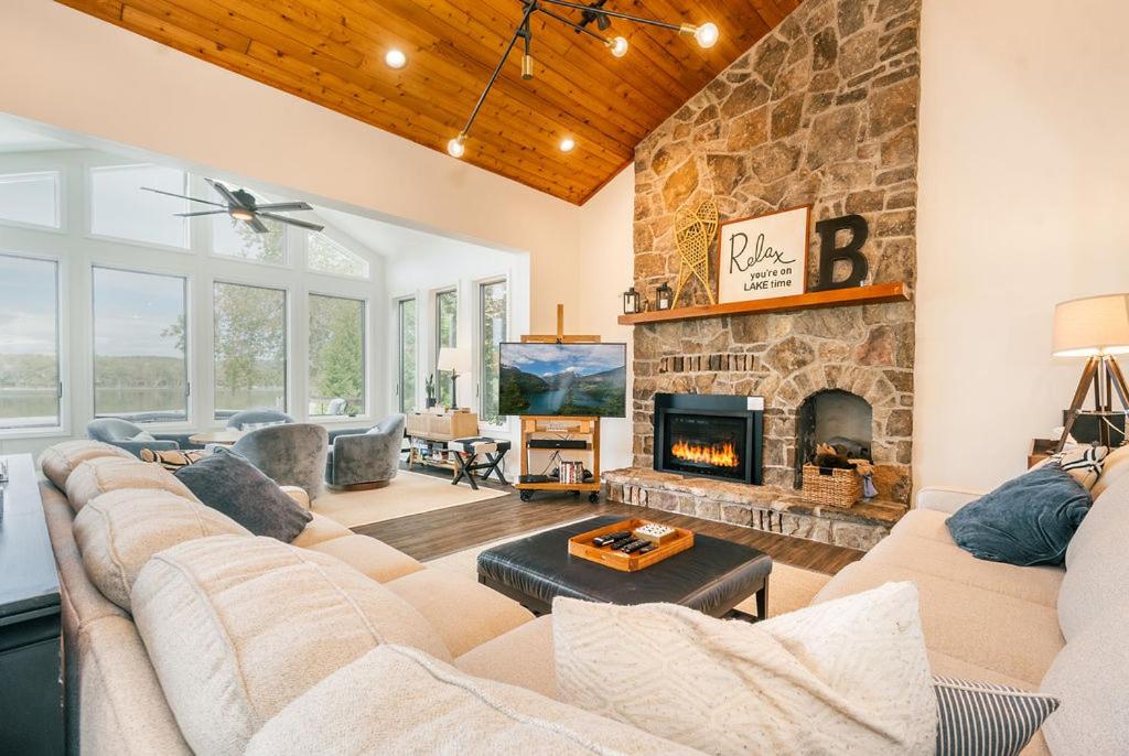 ein Wohnzimmer mit Couch und Kamin in der Unterkunft Reel Chill- 4 bedroom home with Dock, Swimspa, Hot tub! in Thayerville