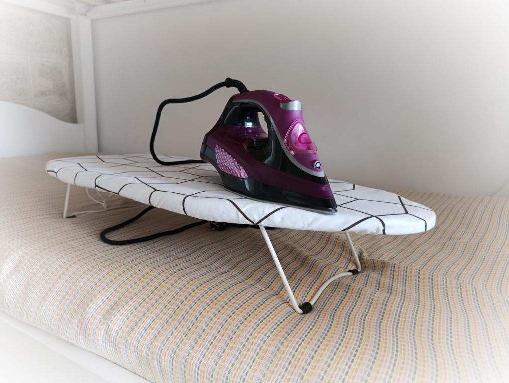 ein Zimmer mit einem Bett mit einem Bügeleisen auf einem Bettgestell in der Unterkunft Antico Gelso in Polignano a Mare