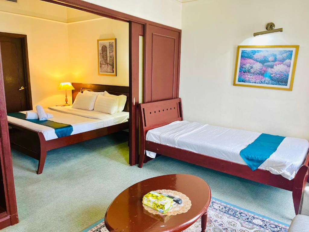 a hotel room with two beds and a table and a table sidx sidx at Max Suites At Barjaya Times Square Kl in Kuala Lumpur