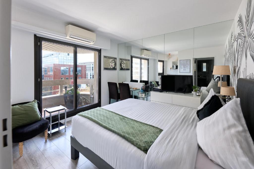Un dormitorio con una cama grande y una sala de estar. en Beautiful modern fully furnished studio, en Levallois-Perret