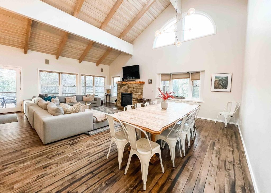 a living room with a table and a couch at Sleeps 30, Riverfront, HotTub, PoolTable, DiscGolf in Three Rivers