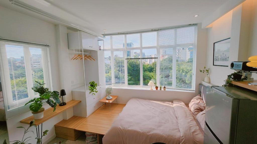 ein Wohnzimmer mit einer Couch und einigen Fenstern in der Unterkunft SkyLush from Cozinema in Ho-Chi-Minh-Stadt