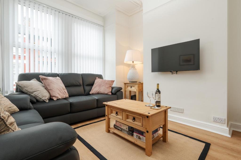 a living room with a couch and a tv at Franks house, 3 Bedroom in Liverpool - sleeps 5, Newly refurbished - long stays welcome, free parking in Litherland