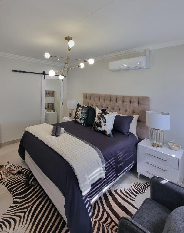 a bedroom with a large bed and a zebra rug at Alice in Wonderland in Kimberley