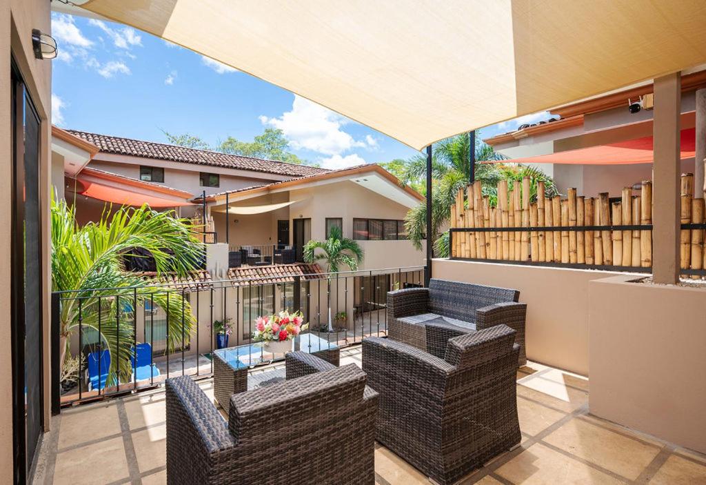 Un patio con sillas y mesas y una valla. en The Cove 10 2br Condo Walk To Ocotal Beach, en Ocotal