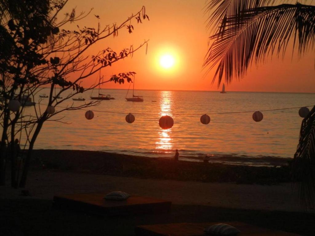 ココにあるCasa Luz 2br Resort Condo Pacfico 4 Guestsの海に沈む夕日と水中のボール