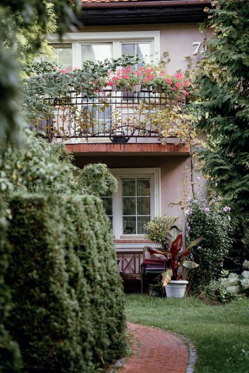 a house with a balcony with flowers on it at Villa Bri in Łeba