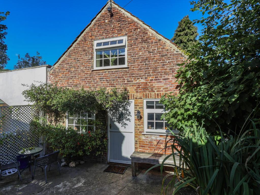 a brick house with a white door and windows at Figgy Cottage in Ripon