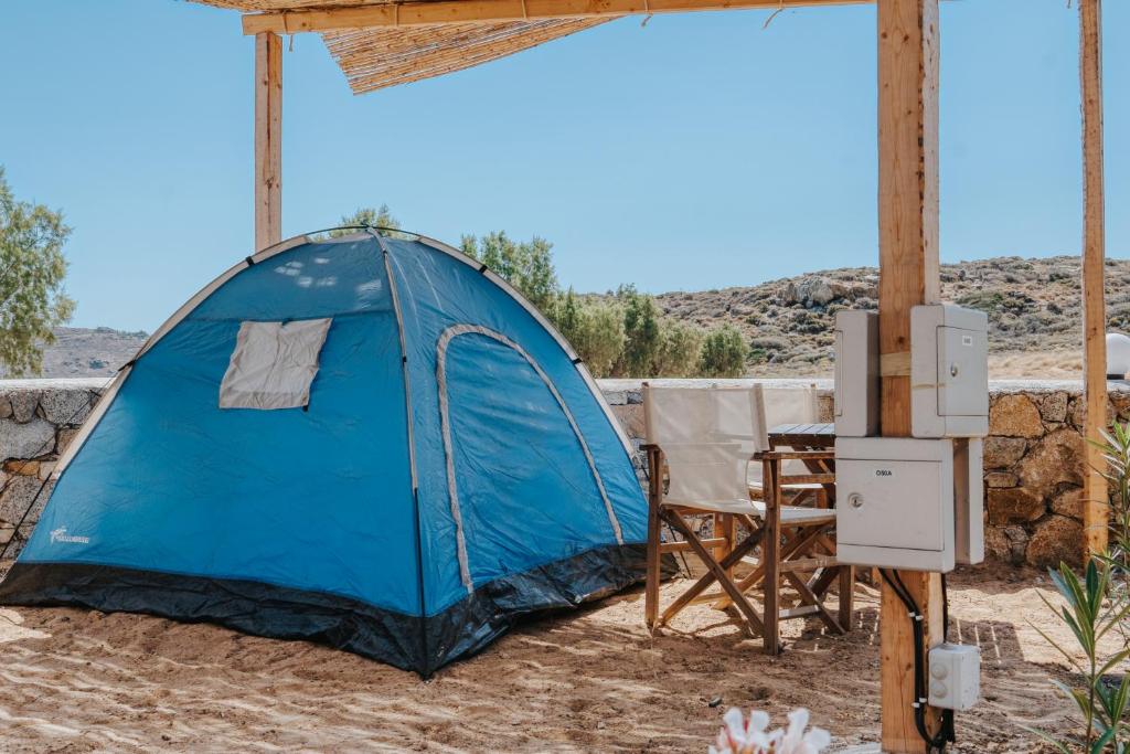 a tent in the desert with a table and chairs at Coralli Camping in Livadakia
