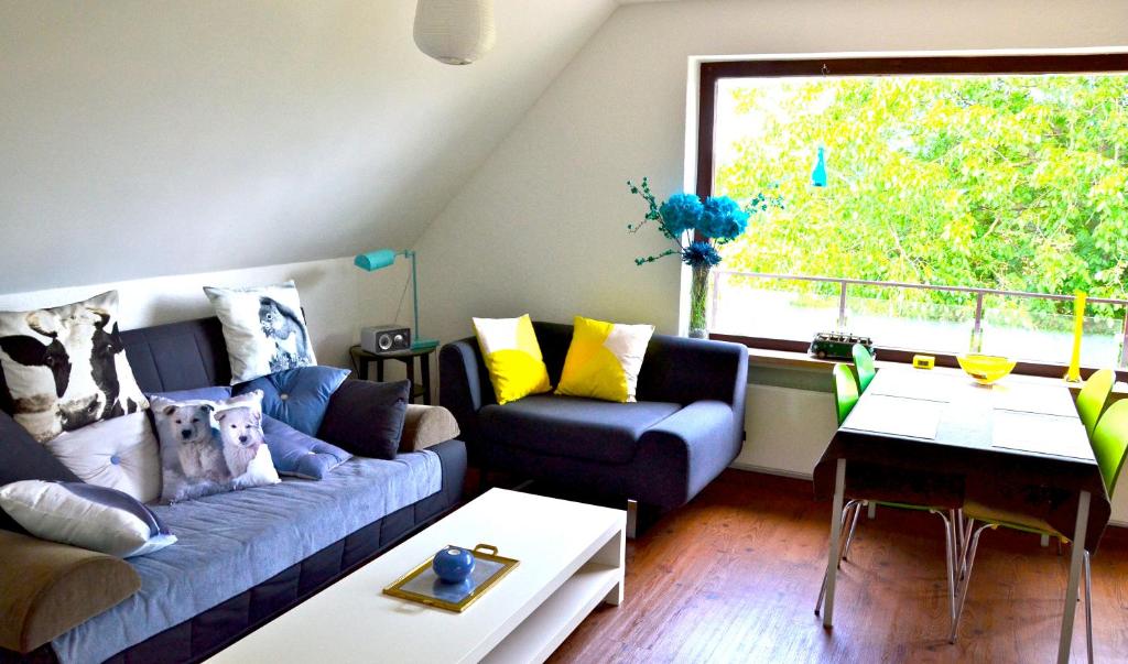 Una sala de estar con un sofá azul y una ventana. en Baumwipfelnest, en Seevetal