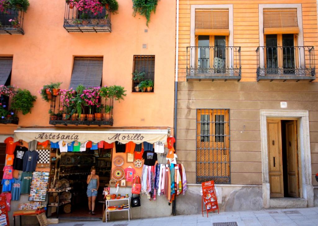 a woman standing in front of a store in front of a building at Apartamento Duplex Gomerez 39 in Granada