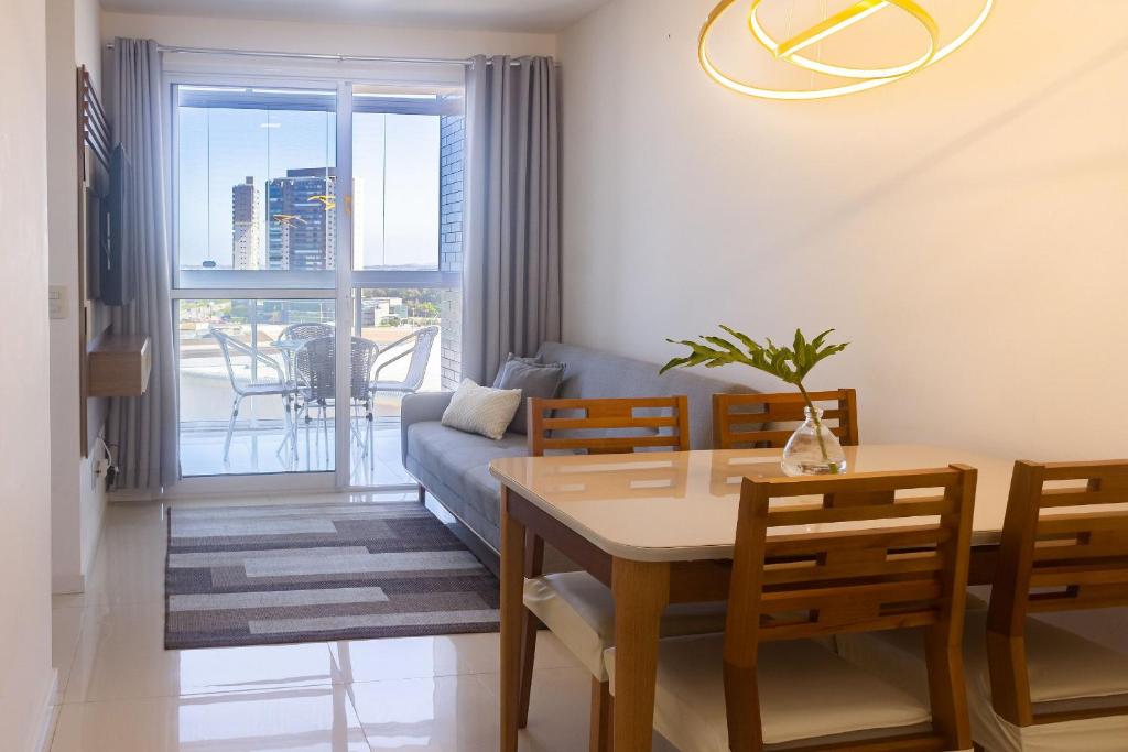 イタパリカにある2Q, Suite com TV, Shopping Boulevard, Vista para Mar, Ed Palmer, NOMDSのテーブルとソファのあるリビングルーム