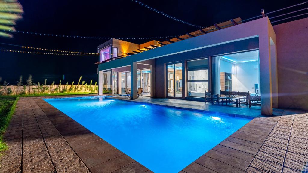 a swimming pool in front of a house at night at Life resort Marrakech 
