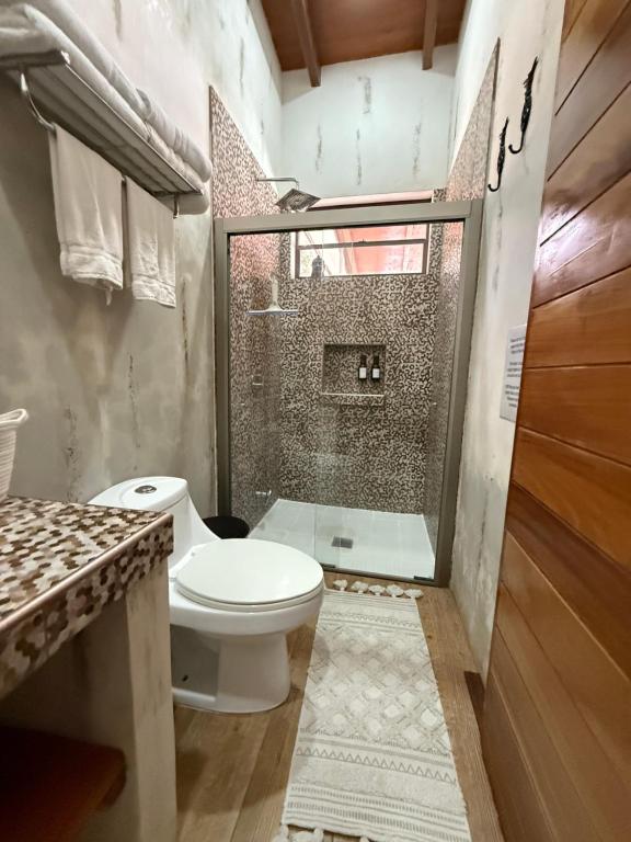 a bathroom with a toilet and a shower at Luxe, confort, exclusivité et localisation Surf City, El Tunco, El Sunzal Villa Oya 3 in Tamanique