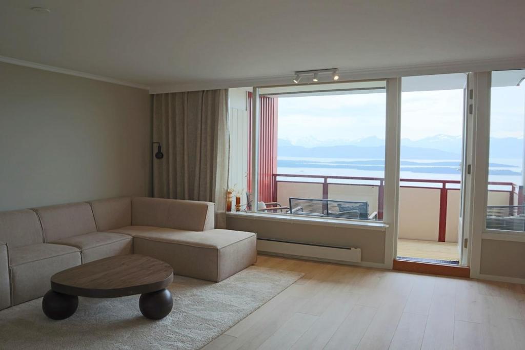 モルデにあるApartment in Moldeのソファと大きな窓のあるリビングルーム