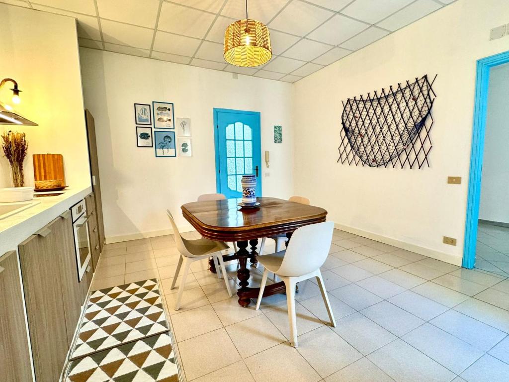 a dining room with a wooden table and chairs at Dipinto di Blu - Faraglioni Seaside Retreat in Aci Castello