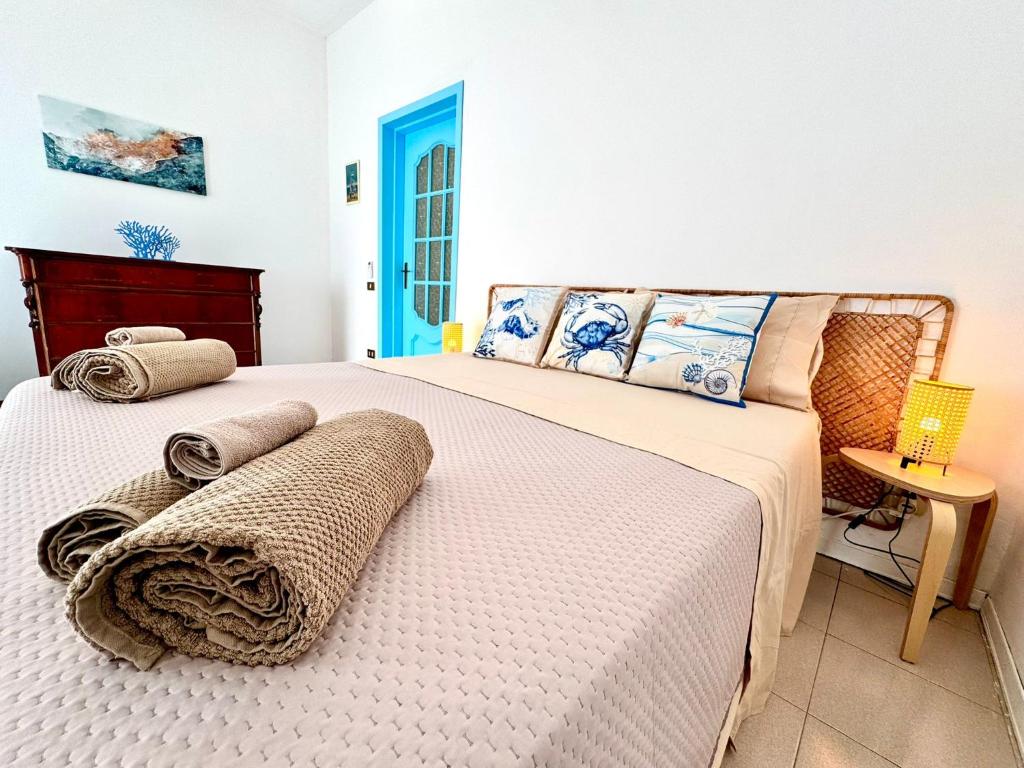 a bedroom with a large bed with towels on it at Dipinto di Blu in Aci Castello
