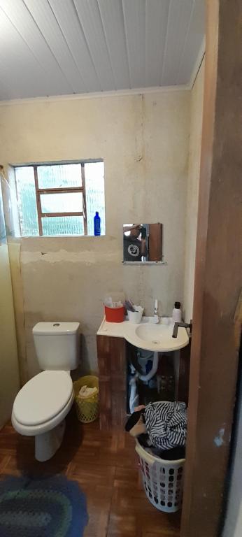 a bathroom with a toilet and a sink at Casa de praia Coroados in Guaratuba