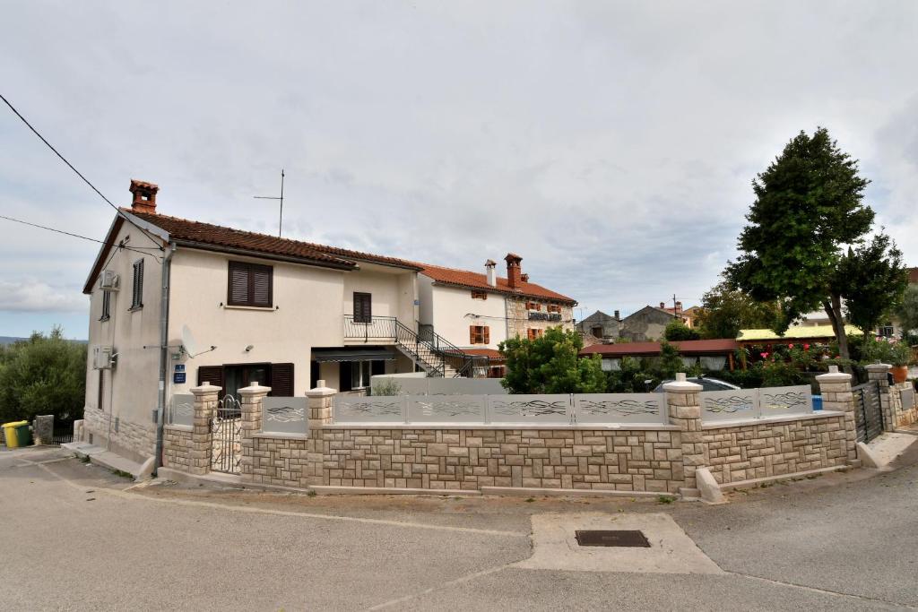 a house behind a brick fence at Apartment Martelina in Manjadvorci