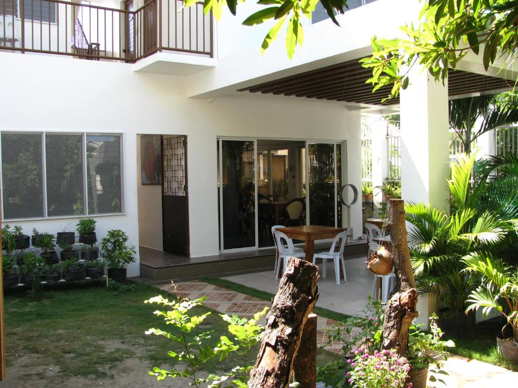 Ein Haus mit einer Terrasse mit einem Tisch und Stühlen in der Unterkunft BJs Seaside in Argao