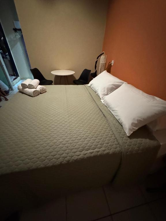 a bedroom with a large bed with white sheets and pillows at Suítes Sossego in Alto Paraíso de Goiás
