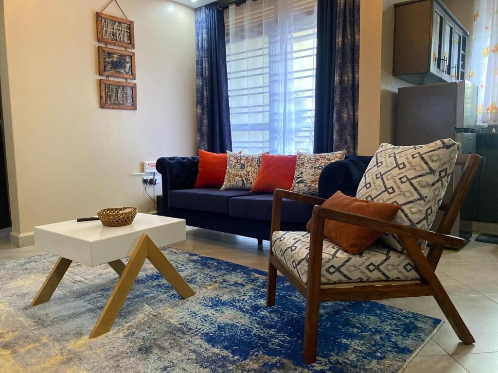 a living room with a couch and a chair at Oasis Villas- Naalya in Kampala