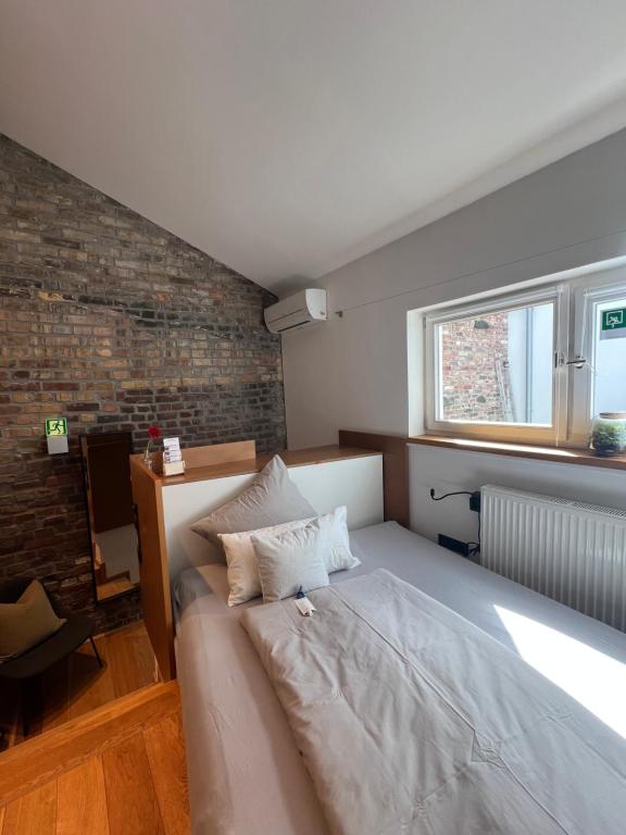 a bedroom with a bed and a brick wall at zons22 I TheTinySpace Architekten Apartment im Denkmal in Dormagen