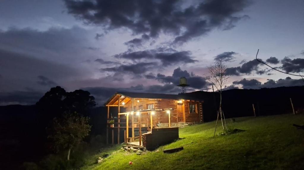 Una casa en una colina por la noche con luces encendidas en Cabaña La Vista, en La Caldera