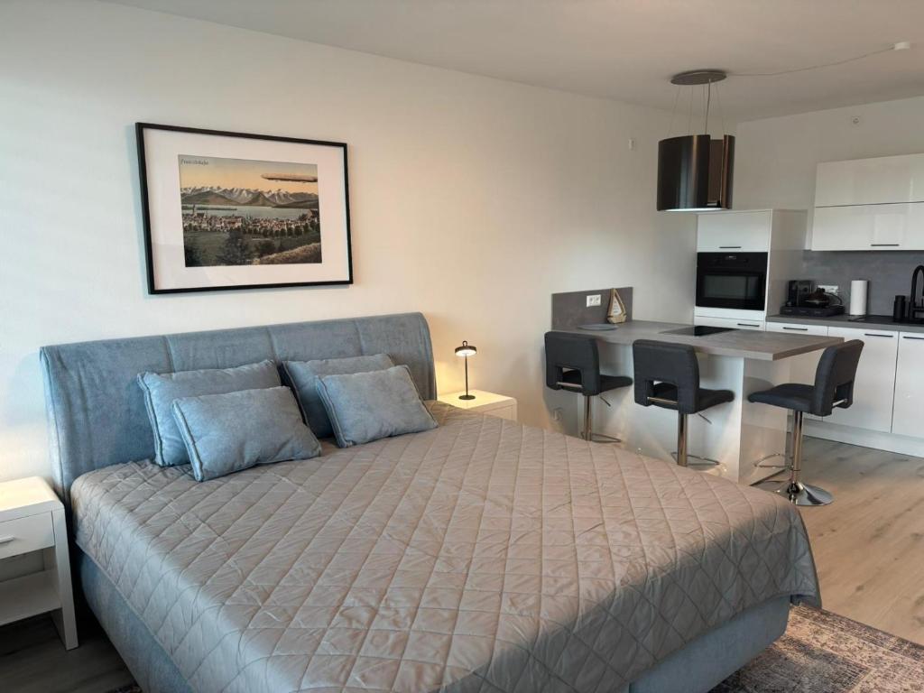 フリードリヒスハーフェンにあるBellevue FN, Appartement mit See- und Bergsichtのベッドのある寝室とテーブルのあるキッチン
