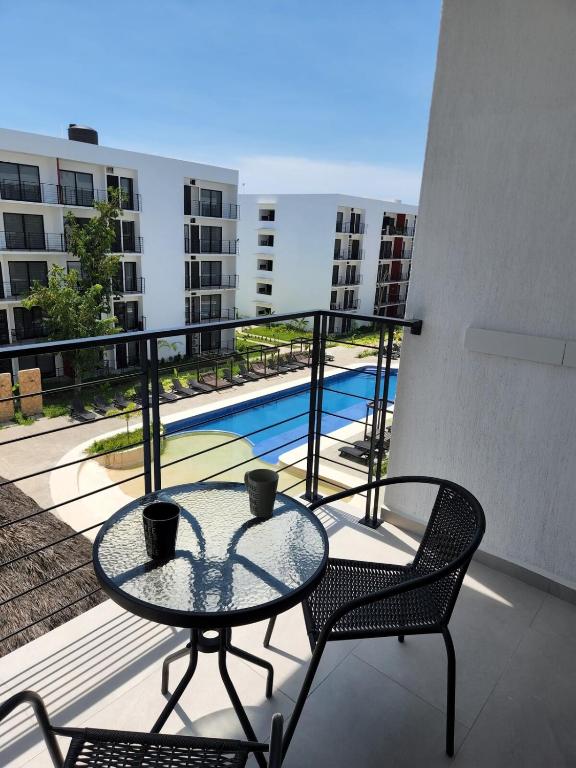 a balcony with a table and chairs and a pool at Moderno y comodo Depto con terraza y alberca in Naranjo