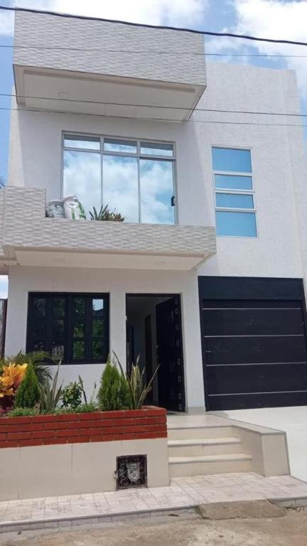 a white house with a black garage at Villa M&G Mompox in Santa Cruz de Mompox
